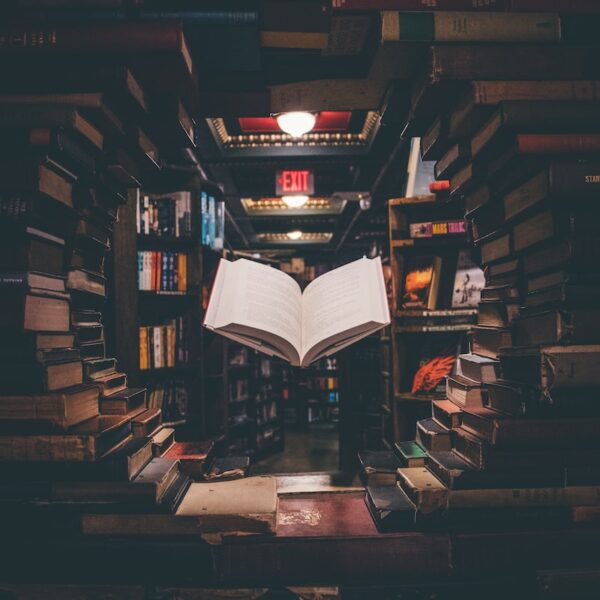 view of floating open book from stacked books in library